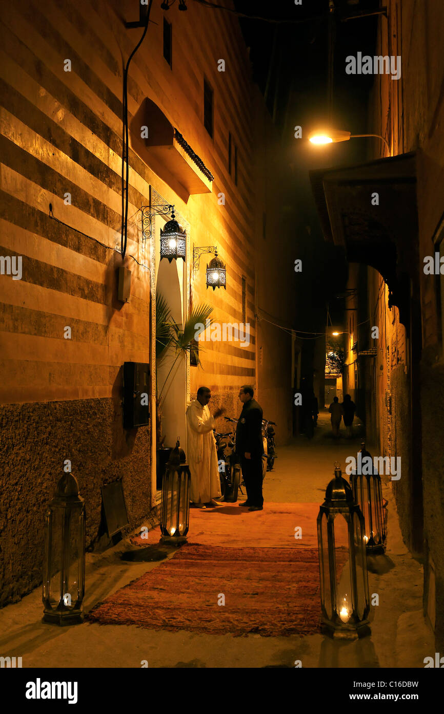 Entrance to an elegant city palace named Riad, night shot, street covered with rugs, Medina, Marrakesh, Morocco, North Africa Stock Photo