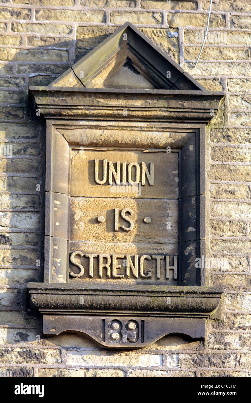 An old inscription stone above a former Co Operative Shop indicating the calues of the organisation Union is Strength Stock Photo