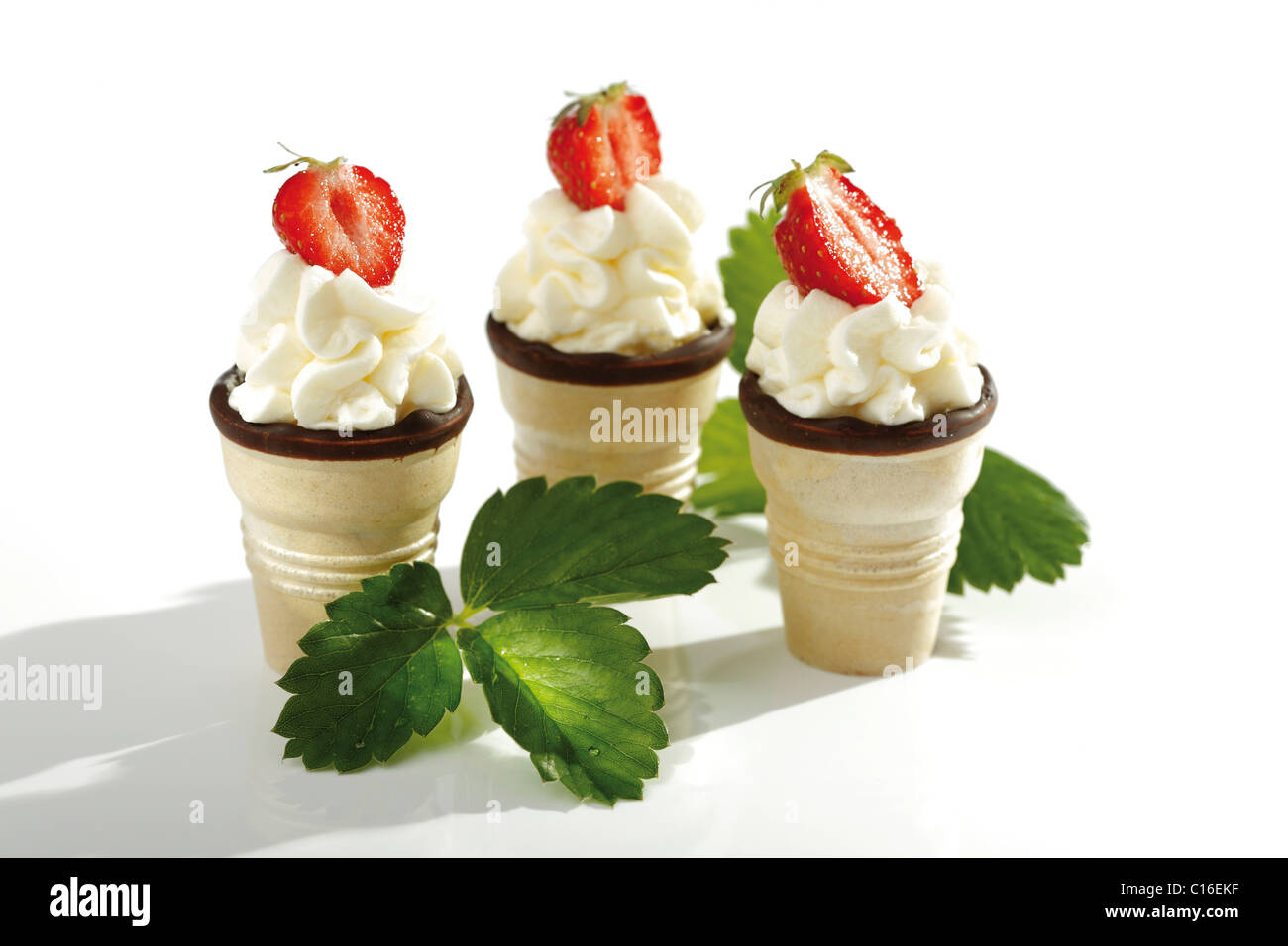 Wafer ice-cream cones with cream and strawberries Stock Photo