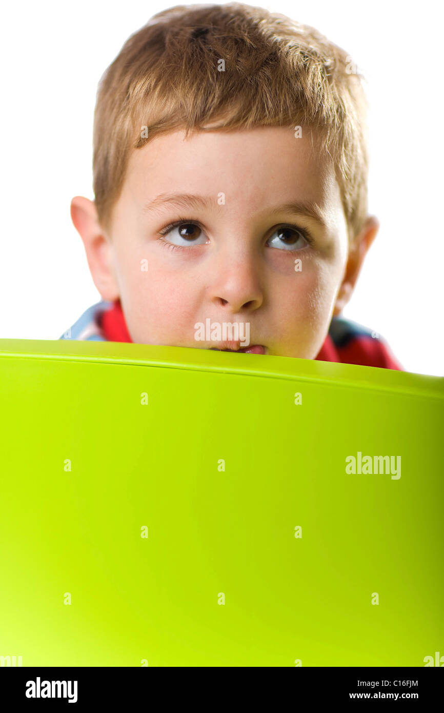 Boy looking over the back of a chair Stock Photo