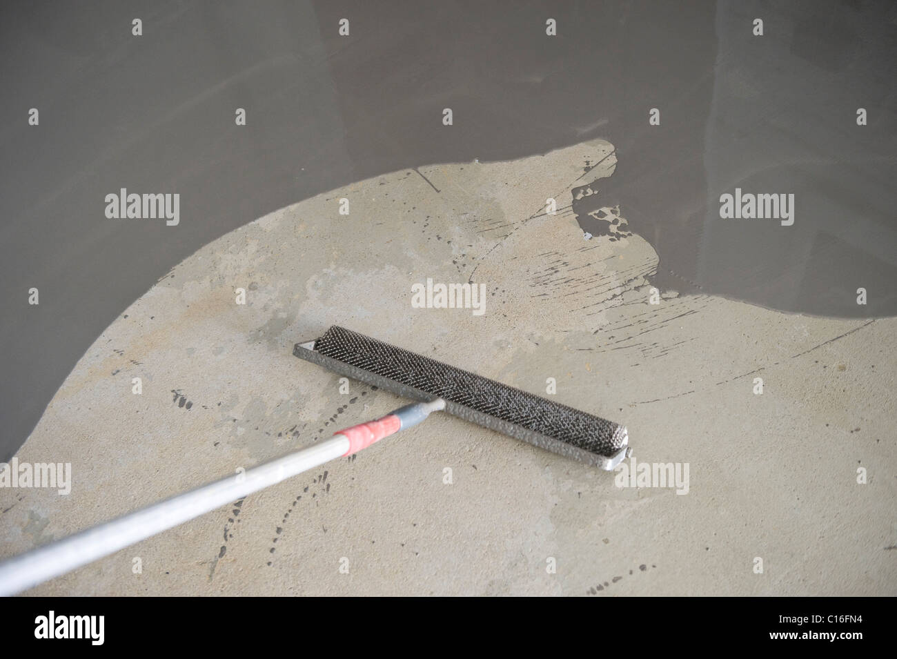 Concrete filler surface and a spiked roller Stock Photo Alamy