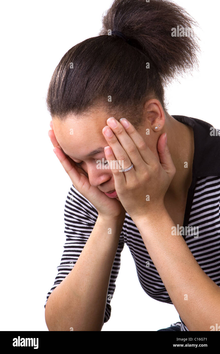 African American woman holds her face in her hands in a state of hopelessness and despair. Stock Photo