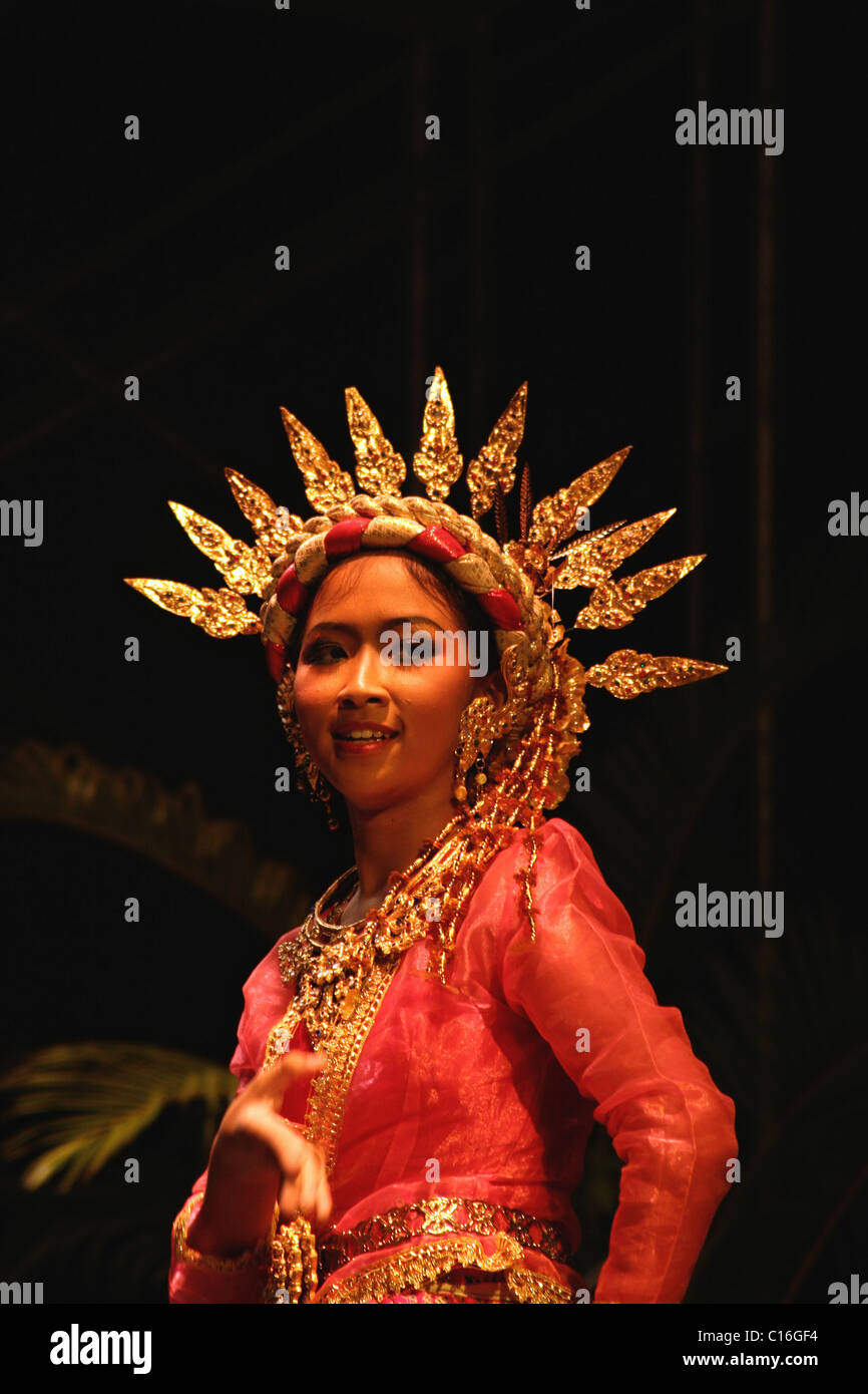 A woman dancer is wearing a bright gold crown while dancing at the 