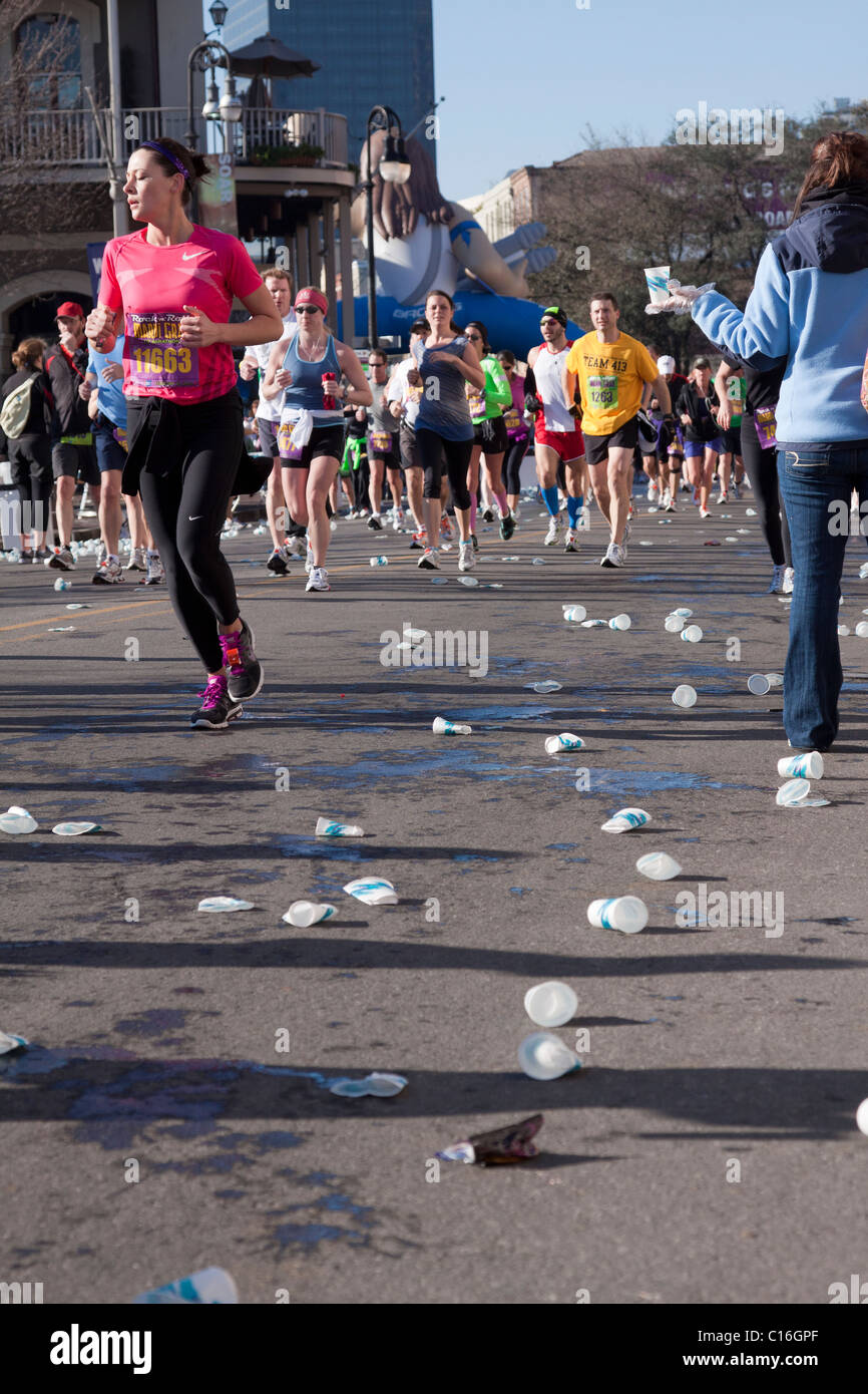 Crowd of racers running by a water station in the rock and roll