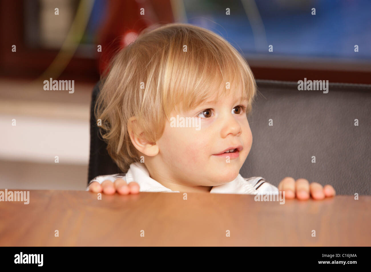 2 year old boy at the edge of the table Stock Photo
