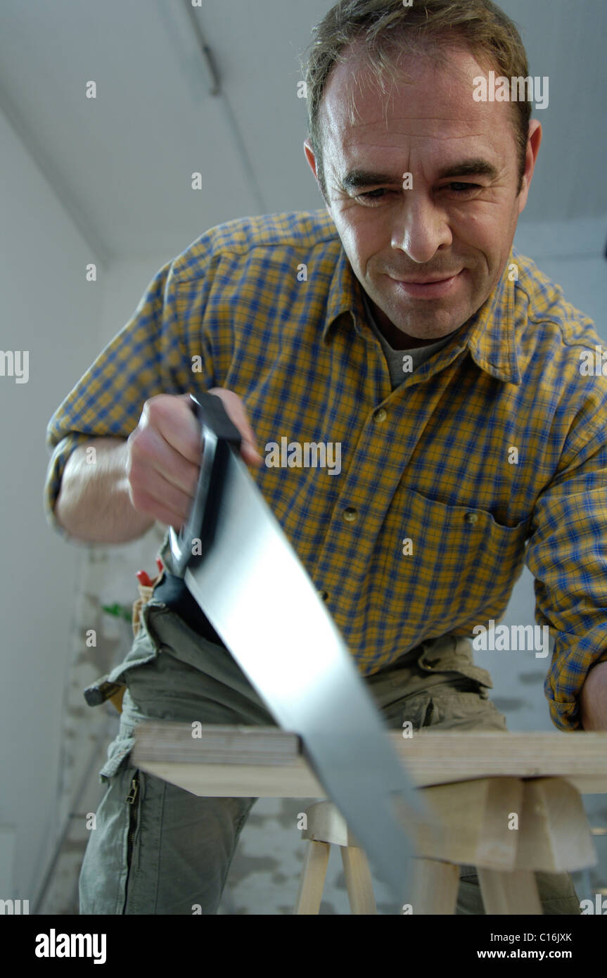 Carpenter using a hand saw Stock Photo Alamy