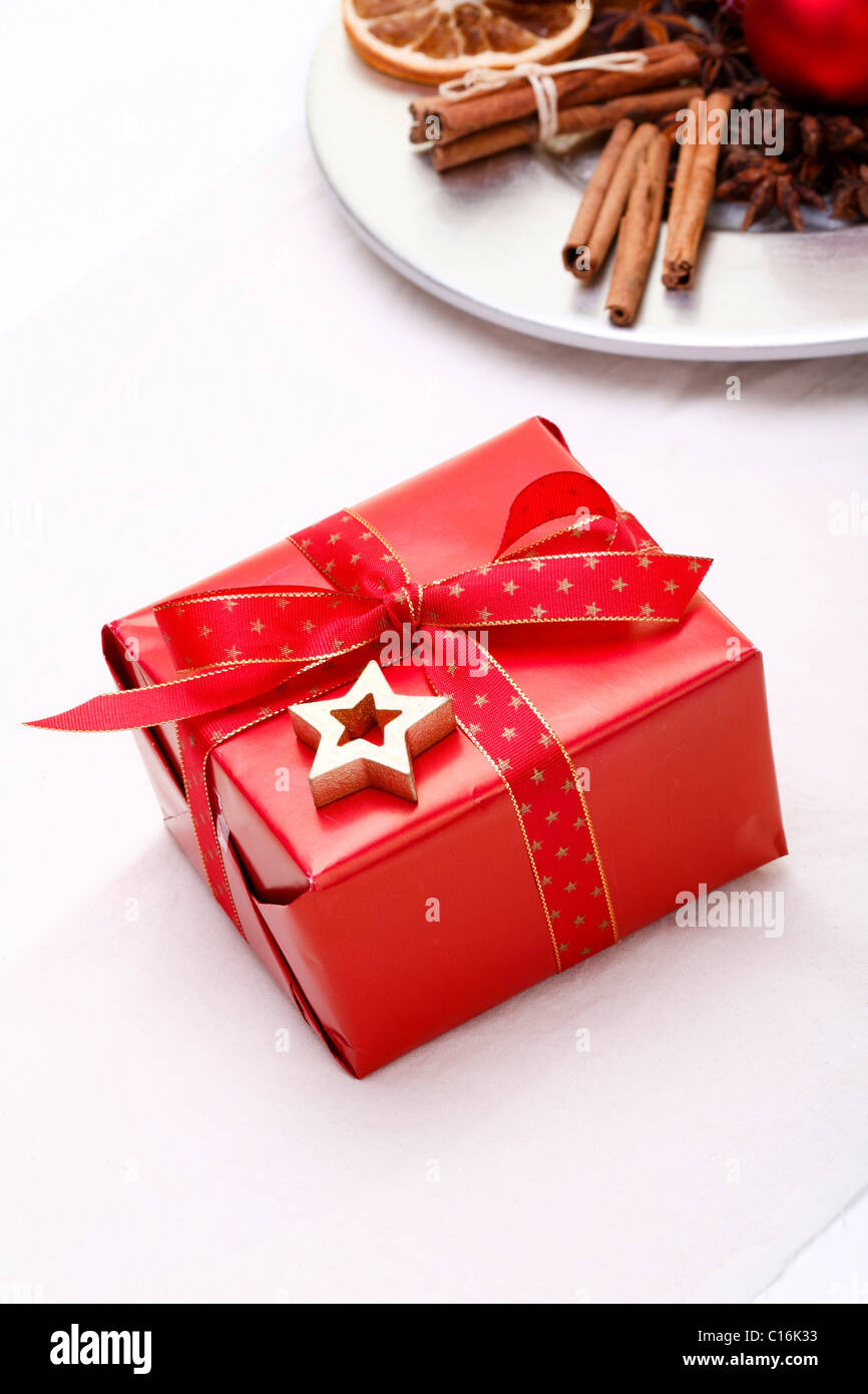 Christmas present next to a plate with Christmas decorations Stock Photo