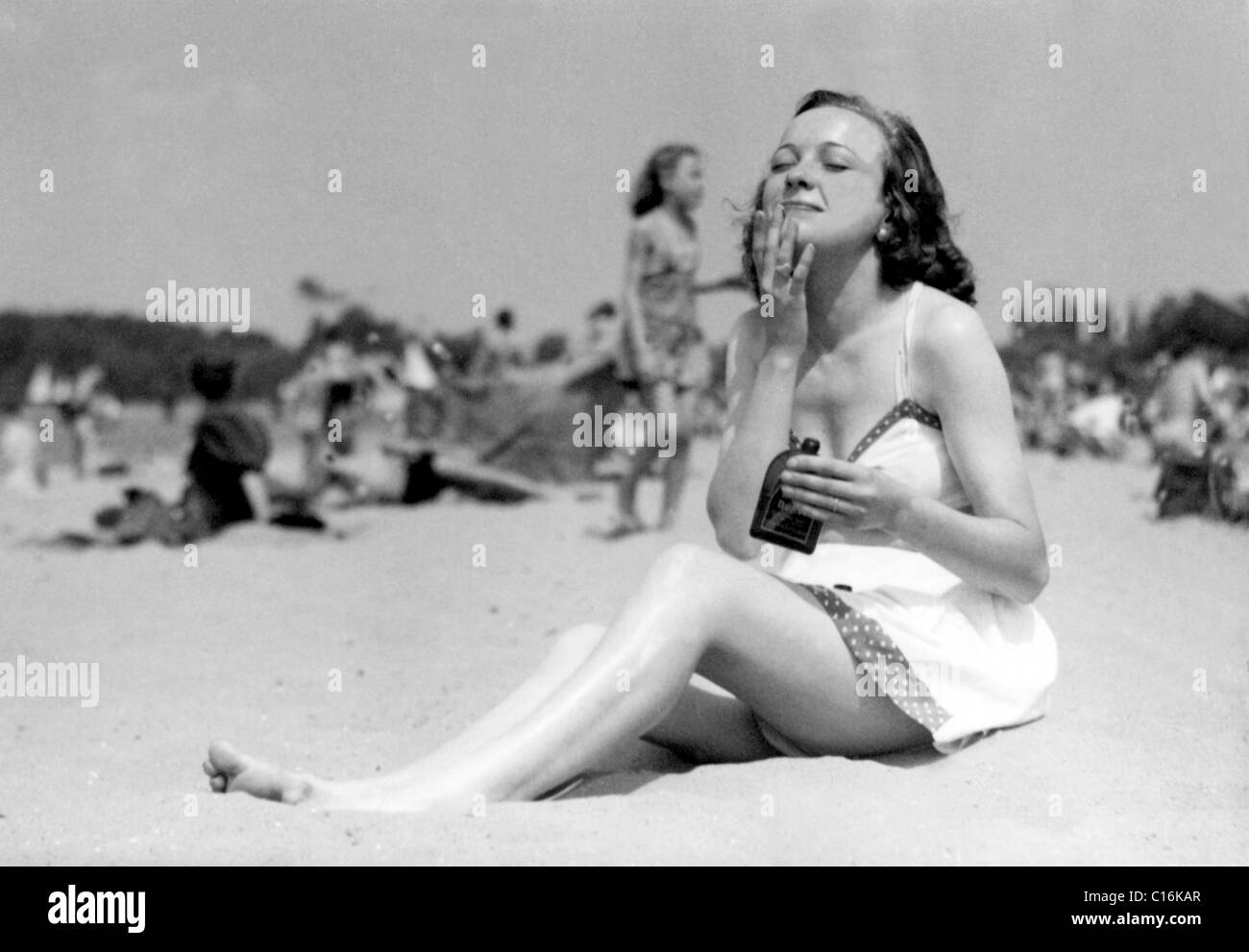 Historic photograph, woman at the beach applying suncream Stock Photo