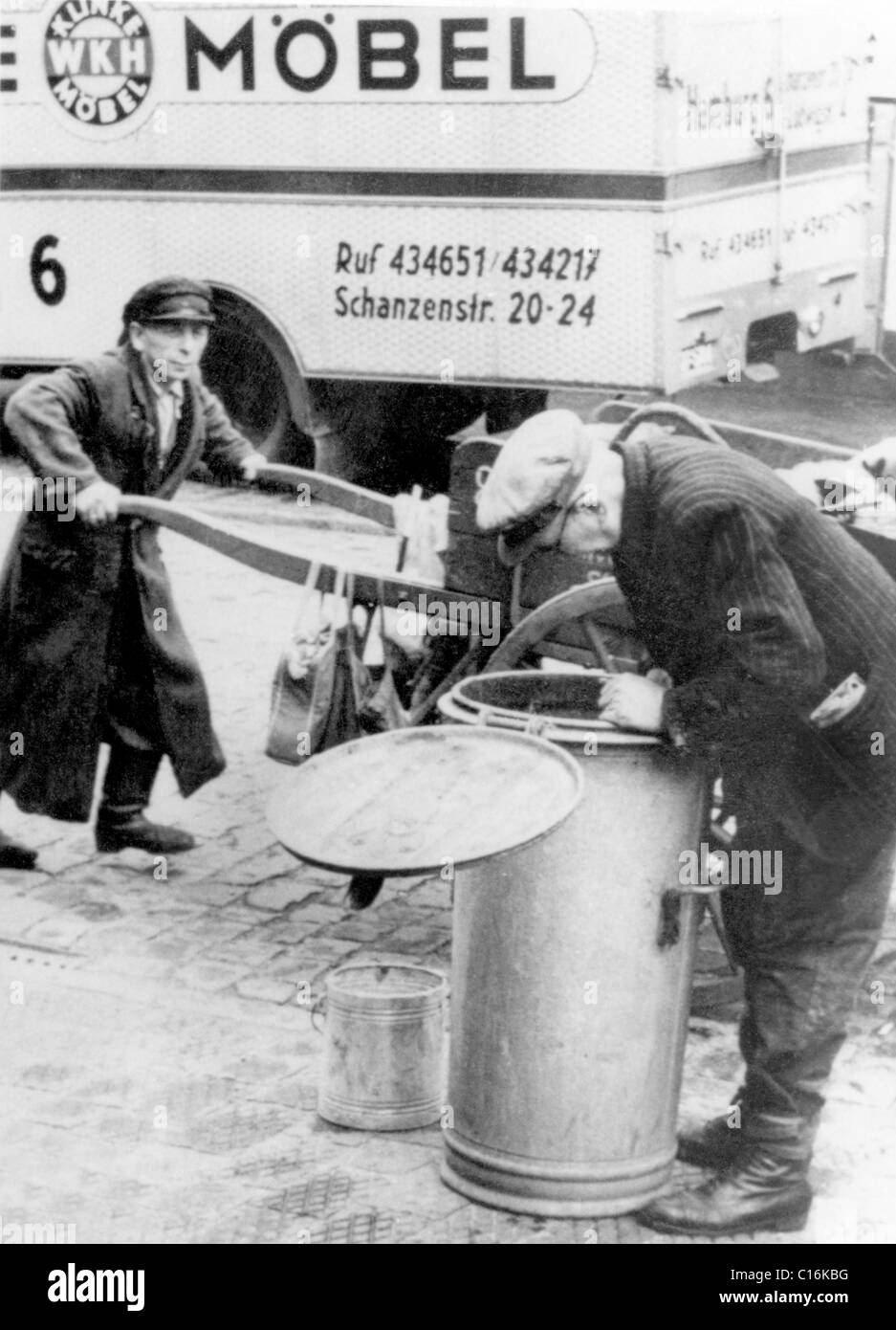 Historic photograph, man sifting through a garbage can Stock Photo Alamy