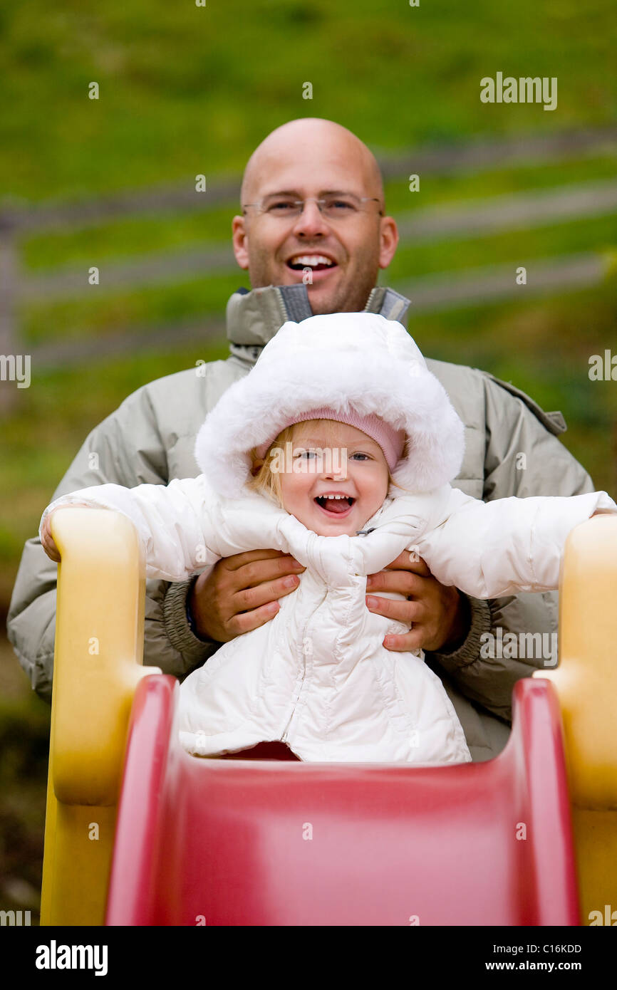 Laughing father and child on a slide, Tyrol, Austria, Europe Stock Photo
