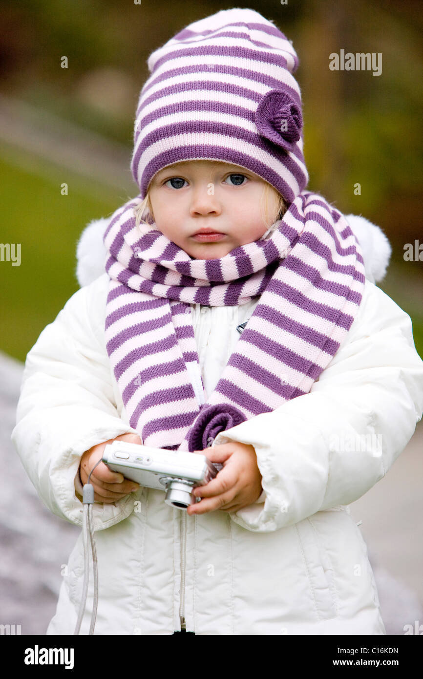 Girl wearing a scarf and a hat, holding a camera, Tyrol, Austria, Europe Stock Photo