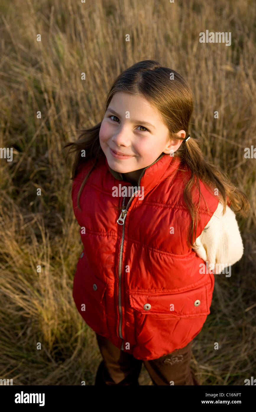 Smiling girl standing in a field Stock Photo - Alamy