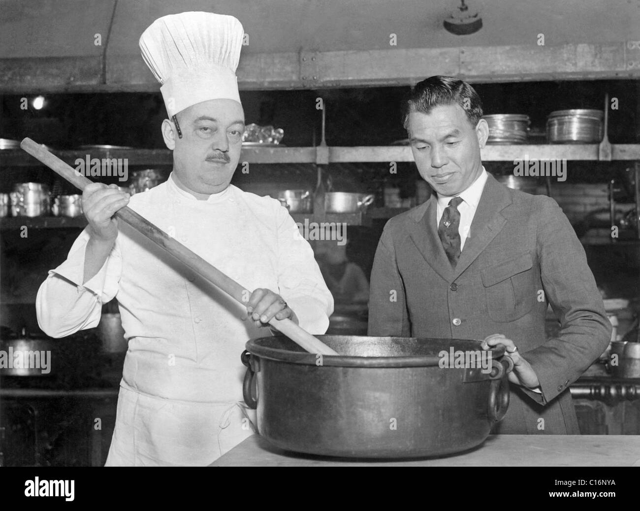 Historic photograph, cook stirring a pot with a large spoon Stock Photo