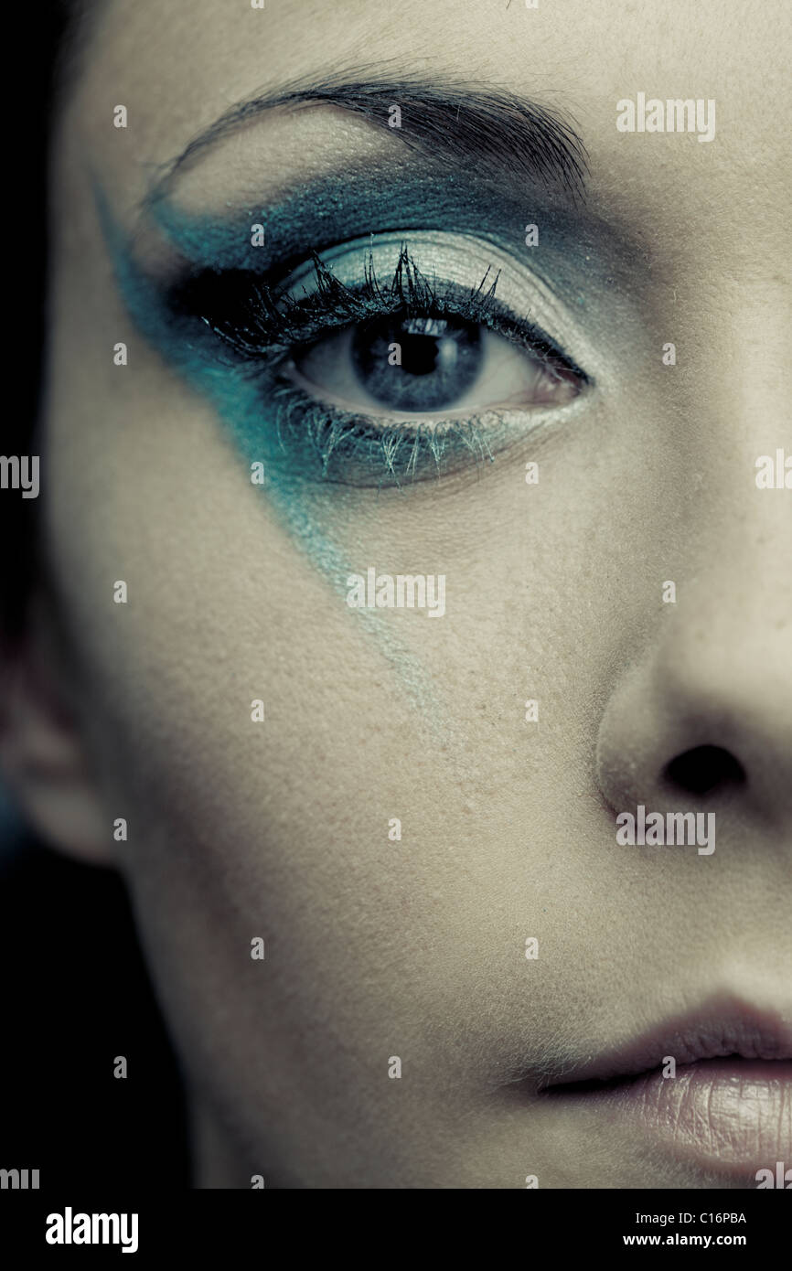 Close up section of a girl's face wearing funky blue eye make up Stock Photo