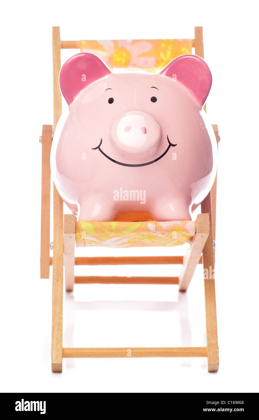 Piggy bank on deck chair studio cutout Stock Photo