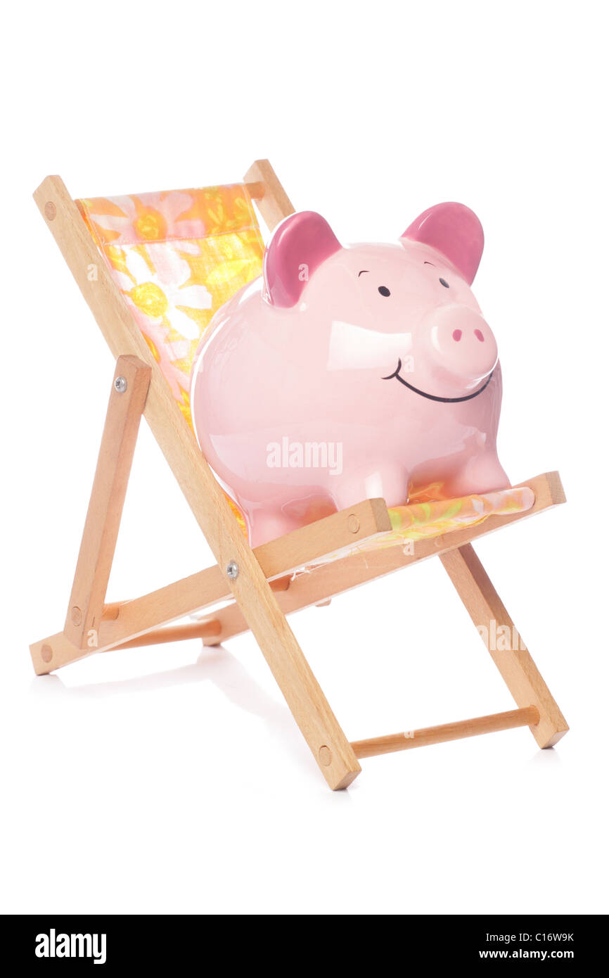 Piggy bank on deck chair studio cutout Stock Photo