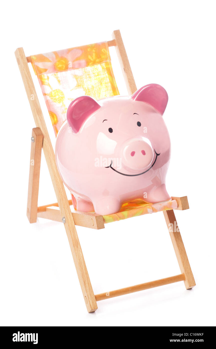 Piggy bank on deck chair studio cutout Stock Photo