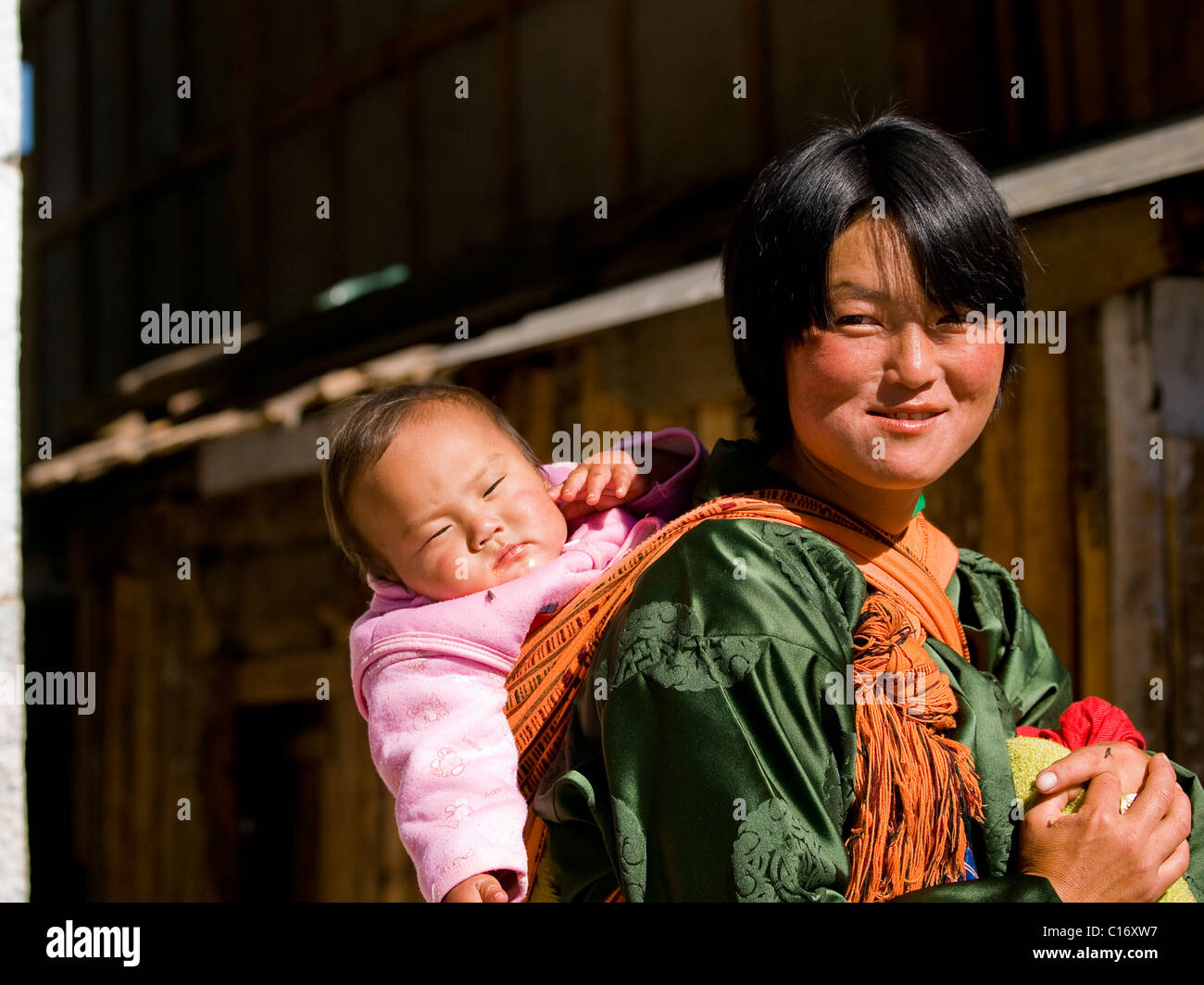 Young mother wearing a traditional Kira with a cute baby on her back