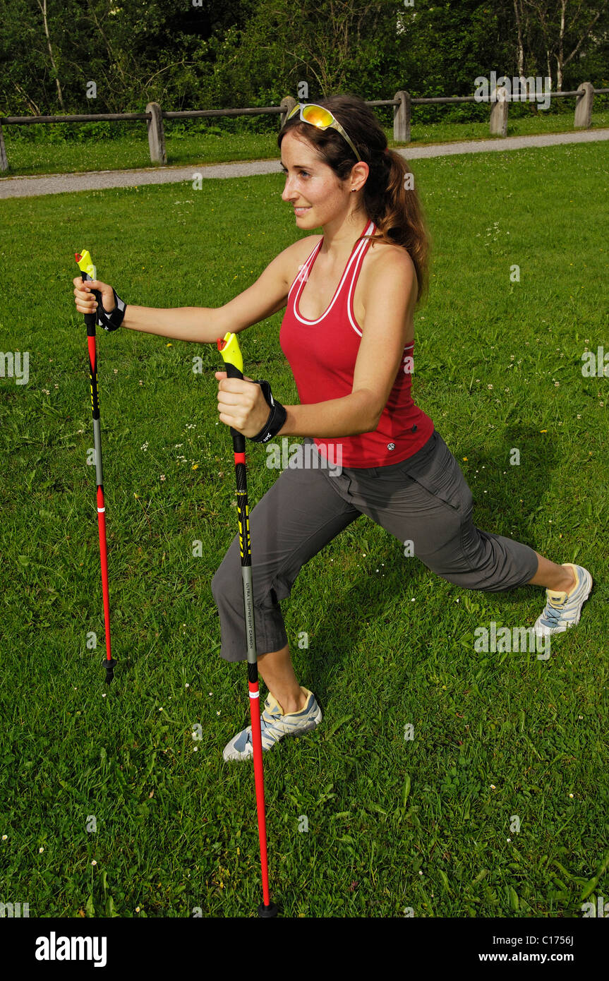Woman doing stretching exercises with Nordic Walking poles, Allgaeu, Bavaria, Germany, Europe Stock Photo