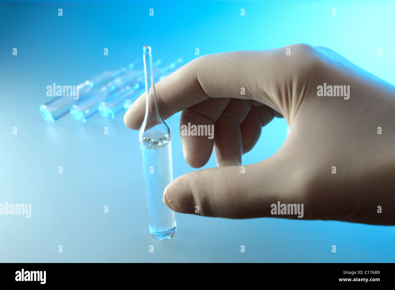 Hand in rubber glove with ampoule Stock Photo Alamy
