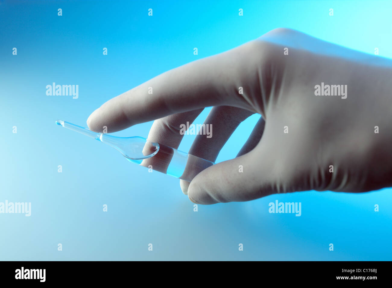 Hand in rubber glove with ampoule Stock Photo Alamy