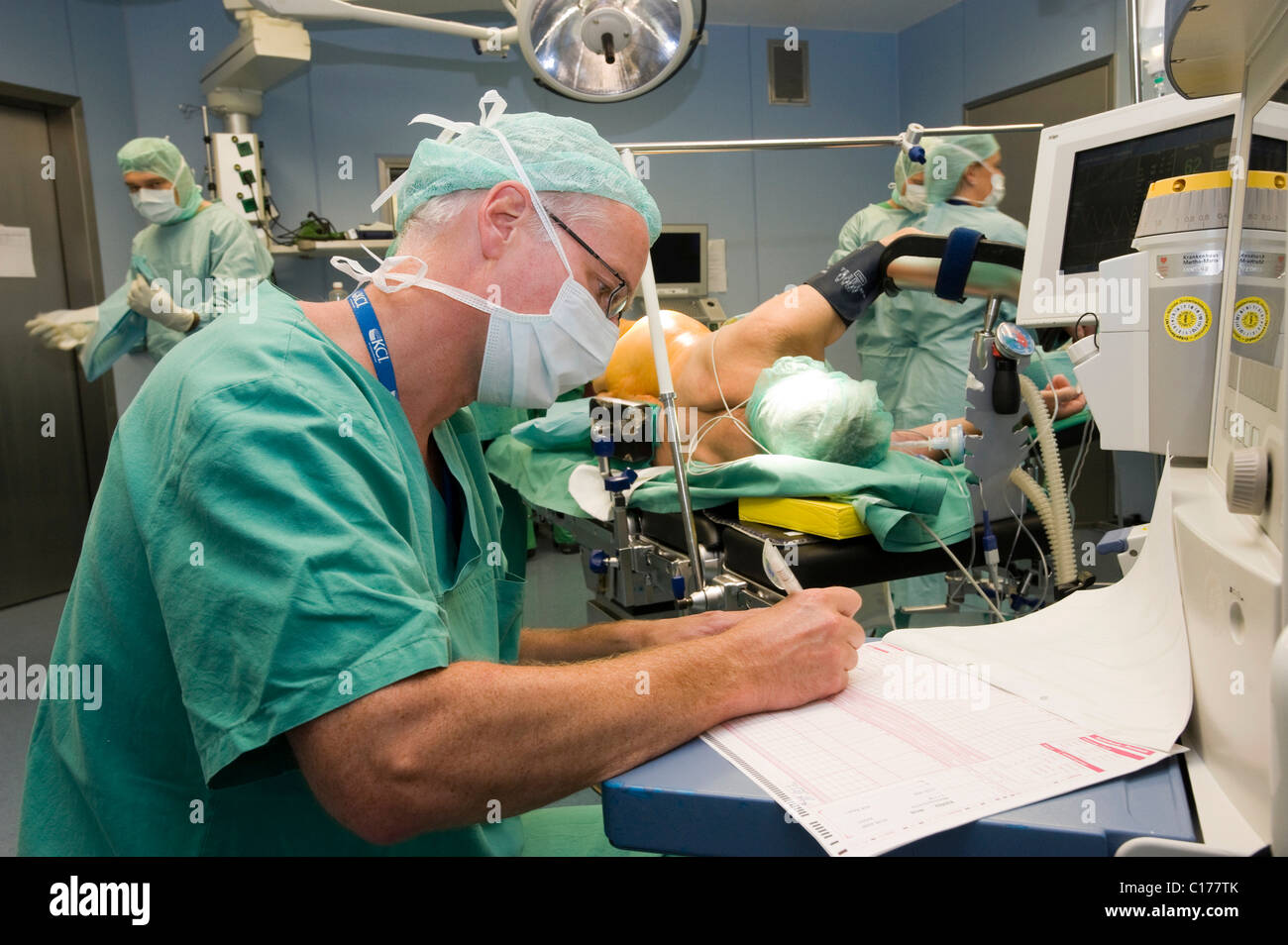 Anaesthetist writing in the surgical protocol shortly before an operation Stock Photo