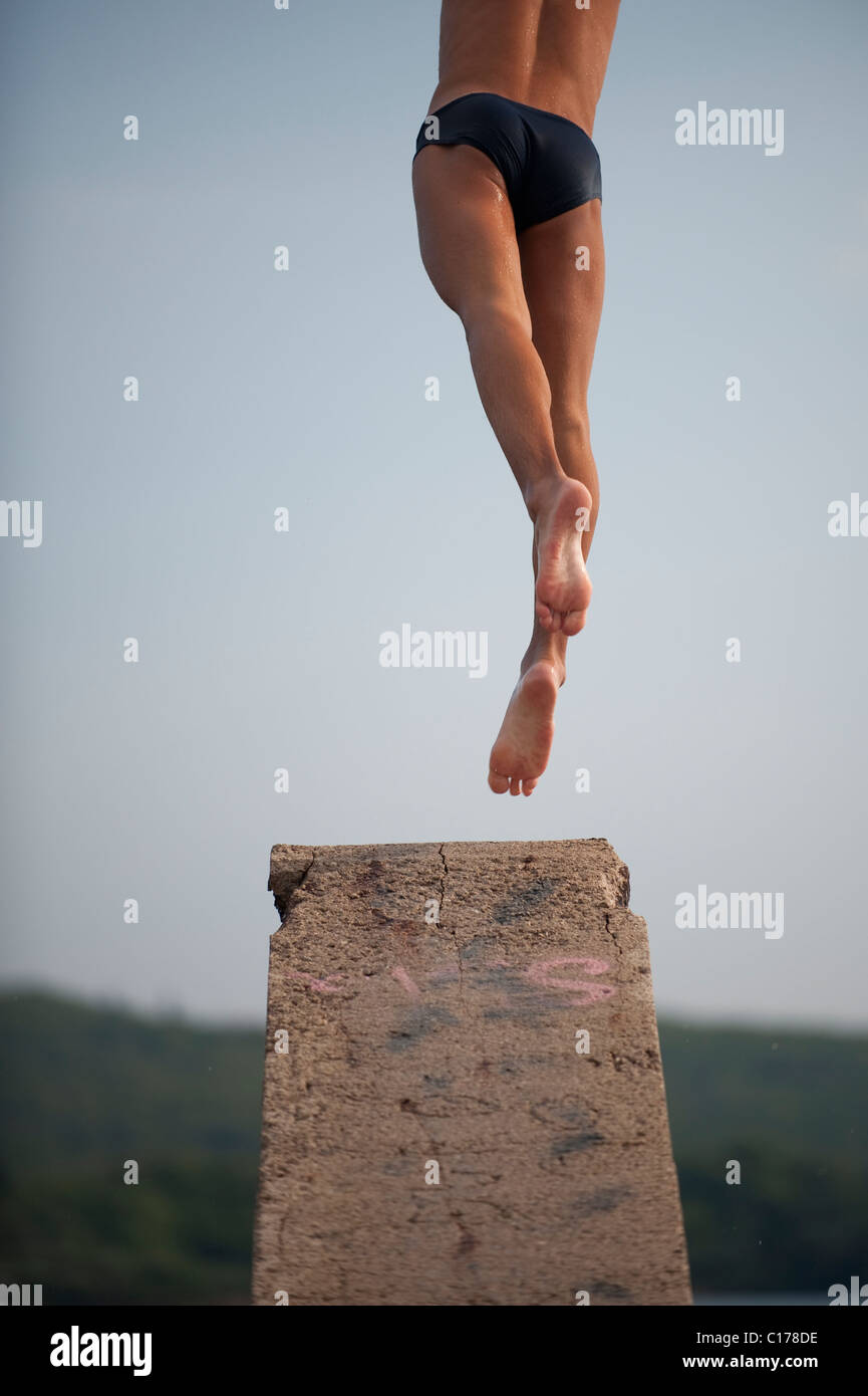 man jumping from diving platform Stock Photo