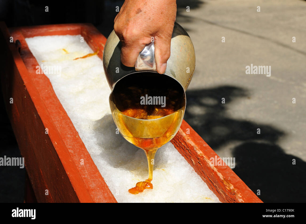 Boiling maple syrup being poured onto snow to make maple syrup sweets