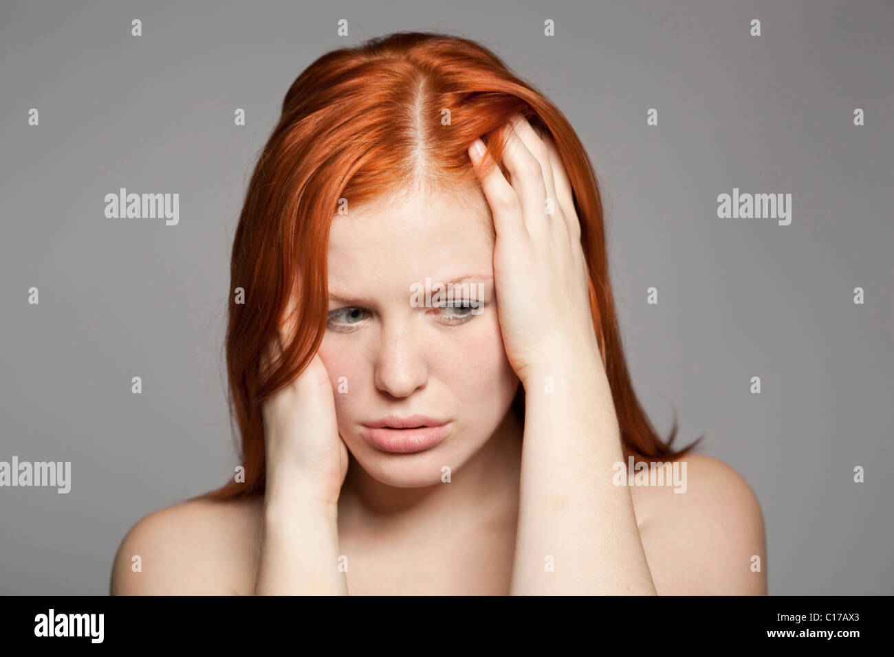 Young, red-haired woman, distressed, sad Stock Photo