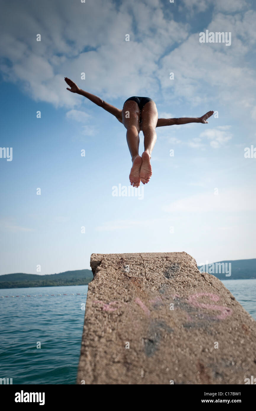 Man diving into lake from platform Stock Photo