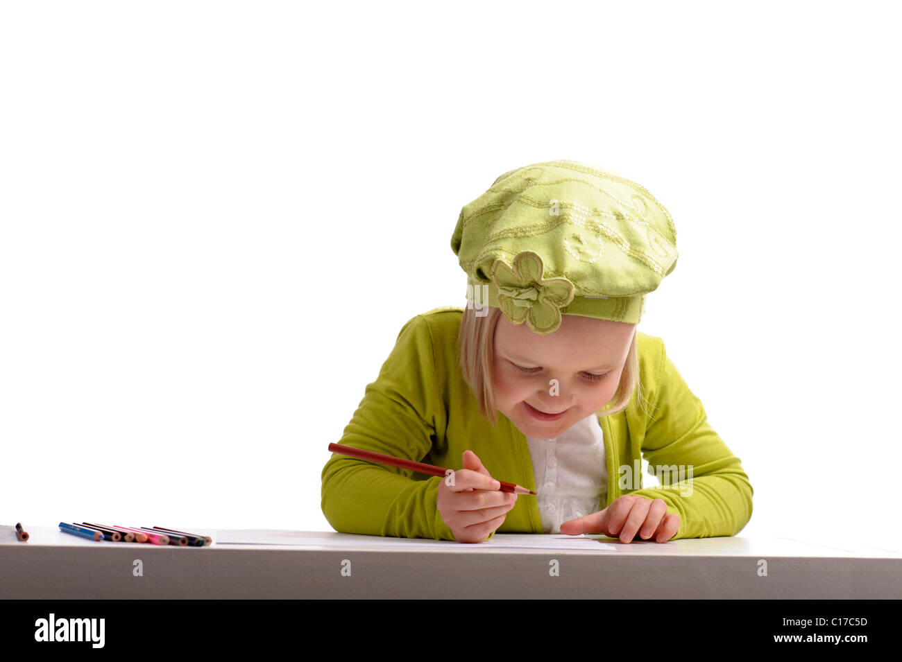 little girl in green drawing with pencils on white background Stock ...