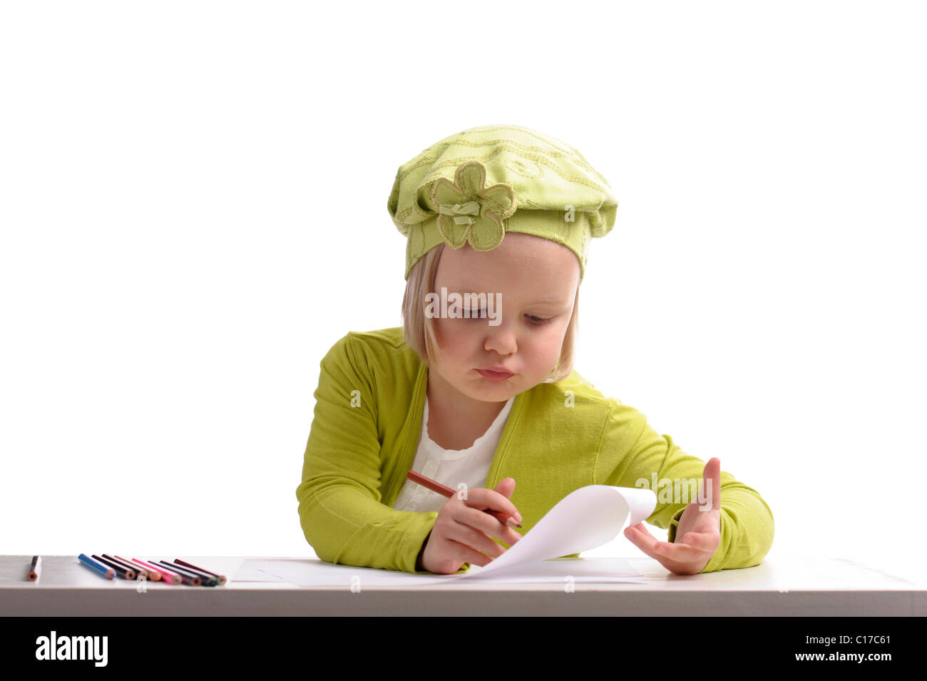 little girl in green drawing with pencils on white background Stock ...