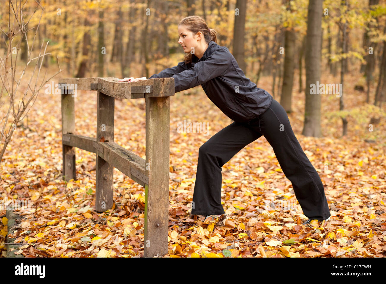 Young dark-haired woman during fitness training in an autumn forest Stock Photo