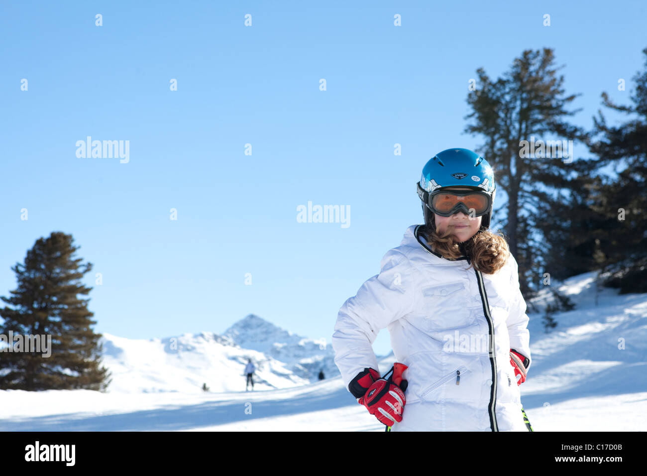 Young skier on the slopes smiling to camera wearing protective helmet and mask Stock Photo