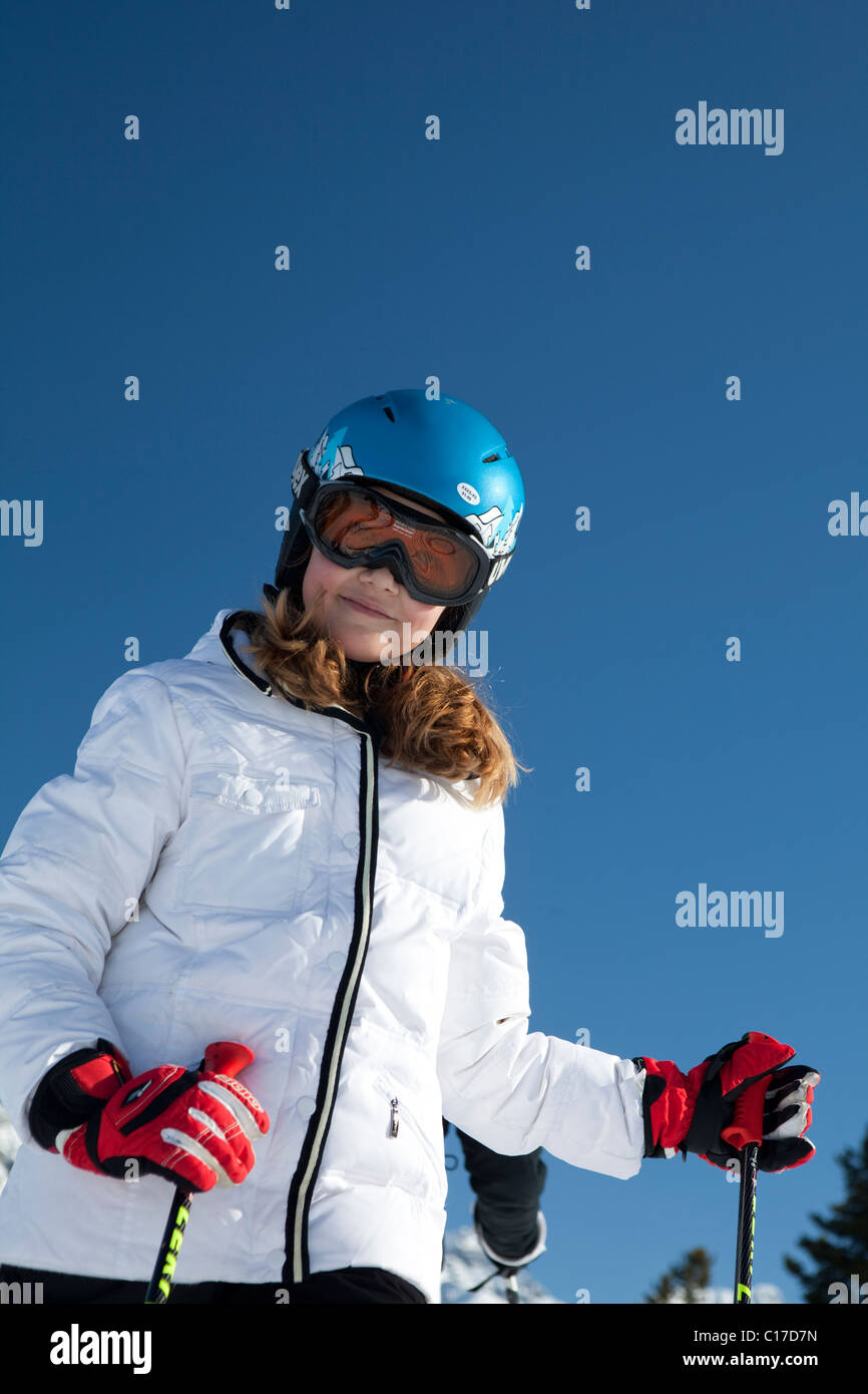 Young female skier wearing protective helmet and mask Stock Photo