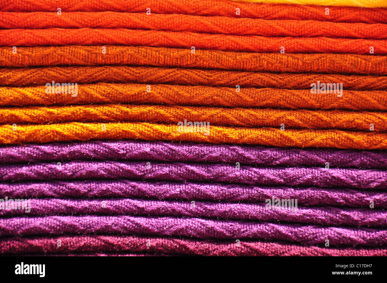 Stack of traditional woven alpaca blankets in orange and purple Stock Photo