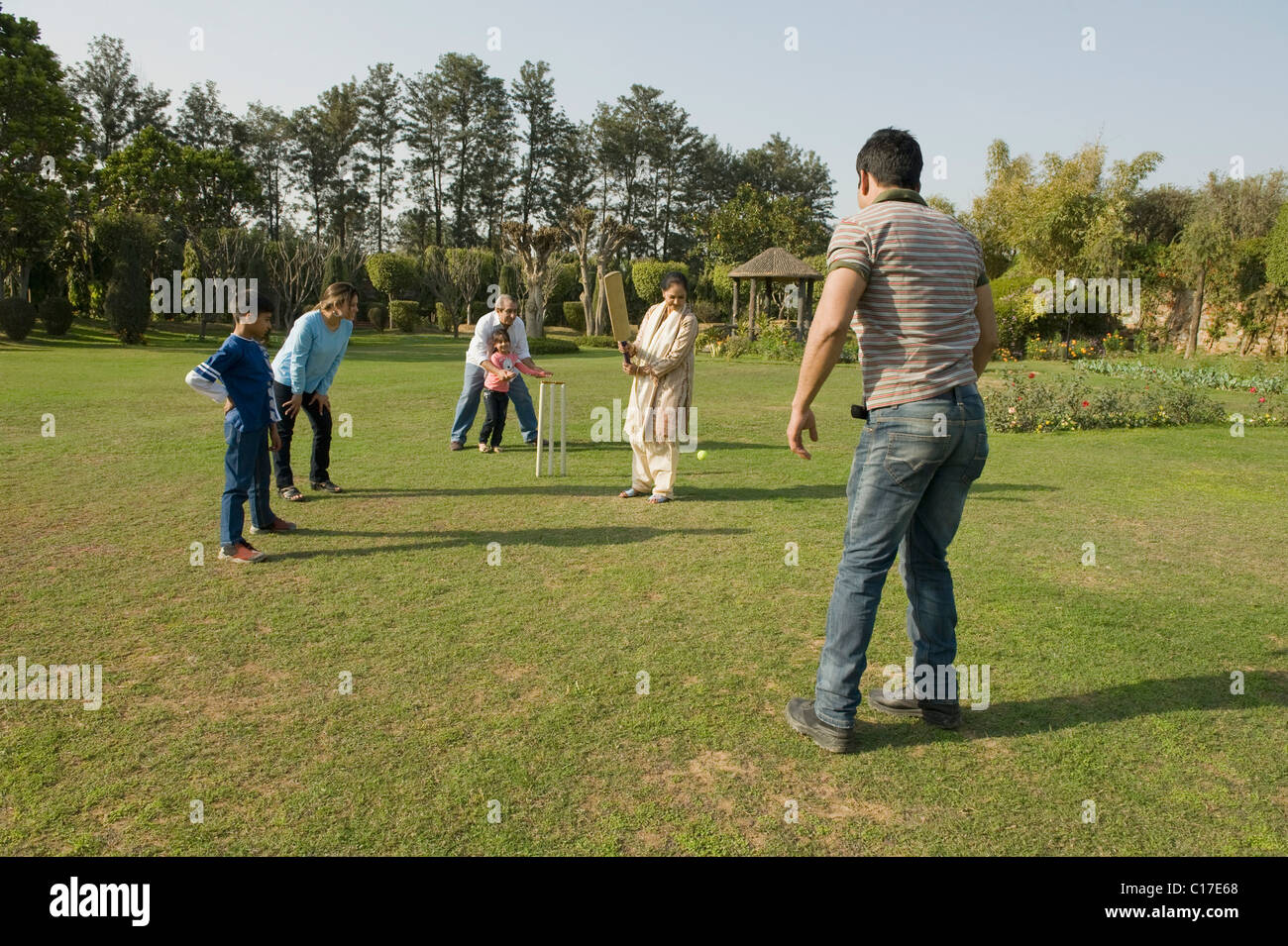 Family playing cricket in lawn Stock Photo Alamy