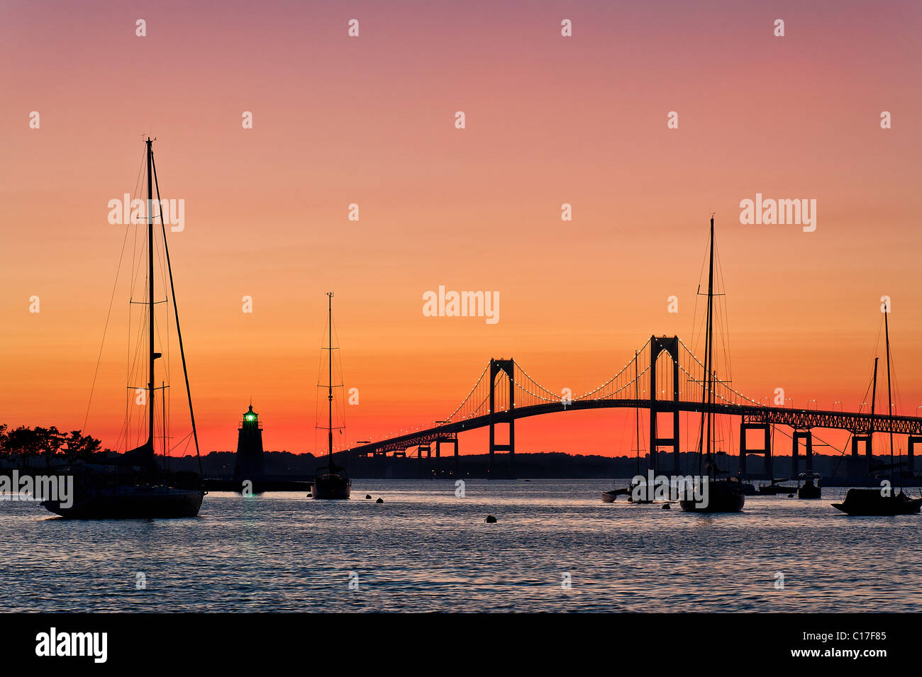 Goat Island lighthouse and the Jamestown or Pell Bridge at sunset, Newport, RI, Rhode Island Stock Photo