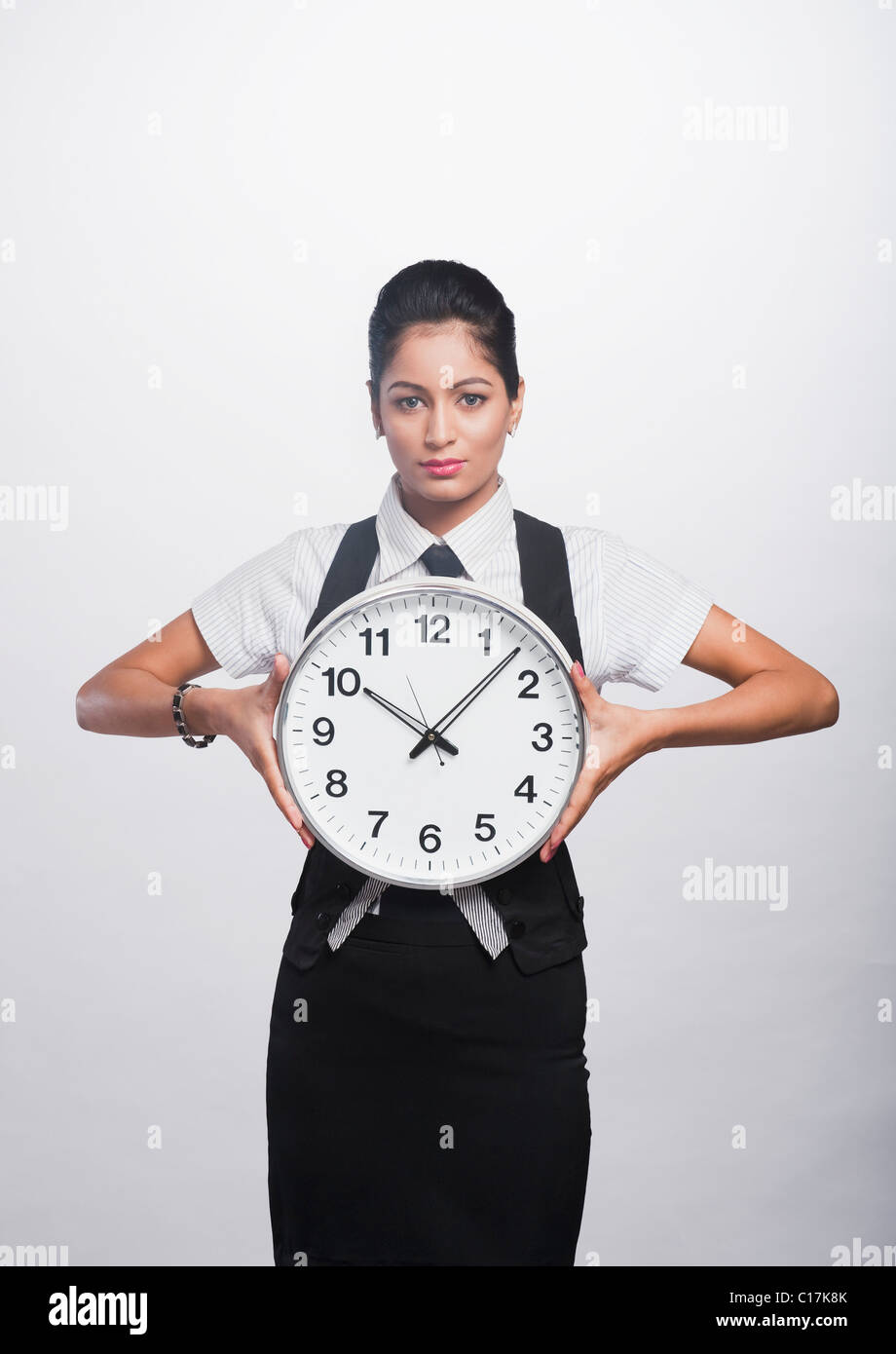 Portrait of a businesswoman holding a clock Stock Photo