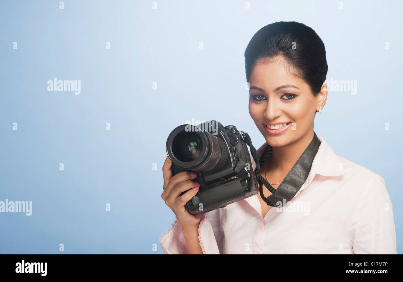Portrait of a businesswoman holding a digital camera and smiling Stock Photo