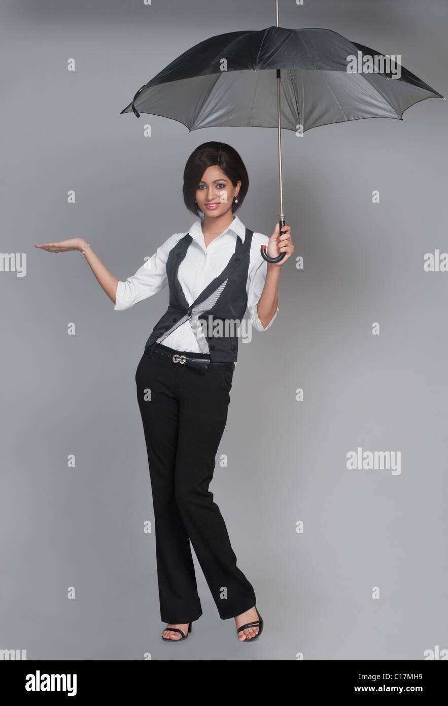 Businesswoman posing with an umbrella and smiling Stock Photo