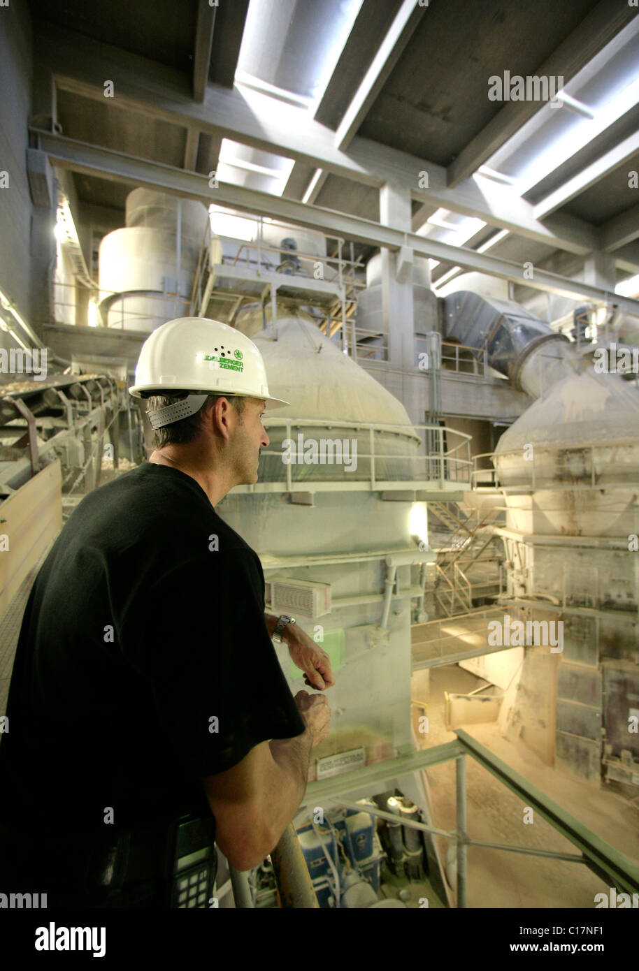 Worker with raw mills, in which crushed stone becomes fine grey powder, cement production in the Schwarzenfeld cement factory of Stock Photo