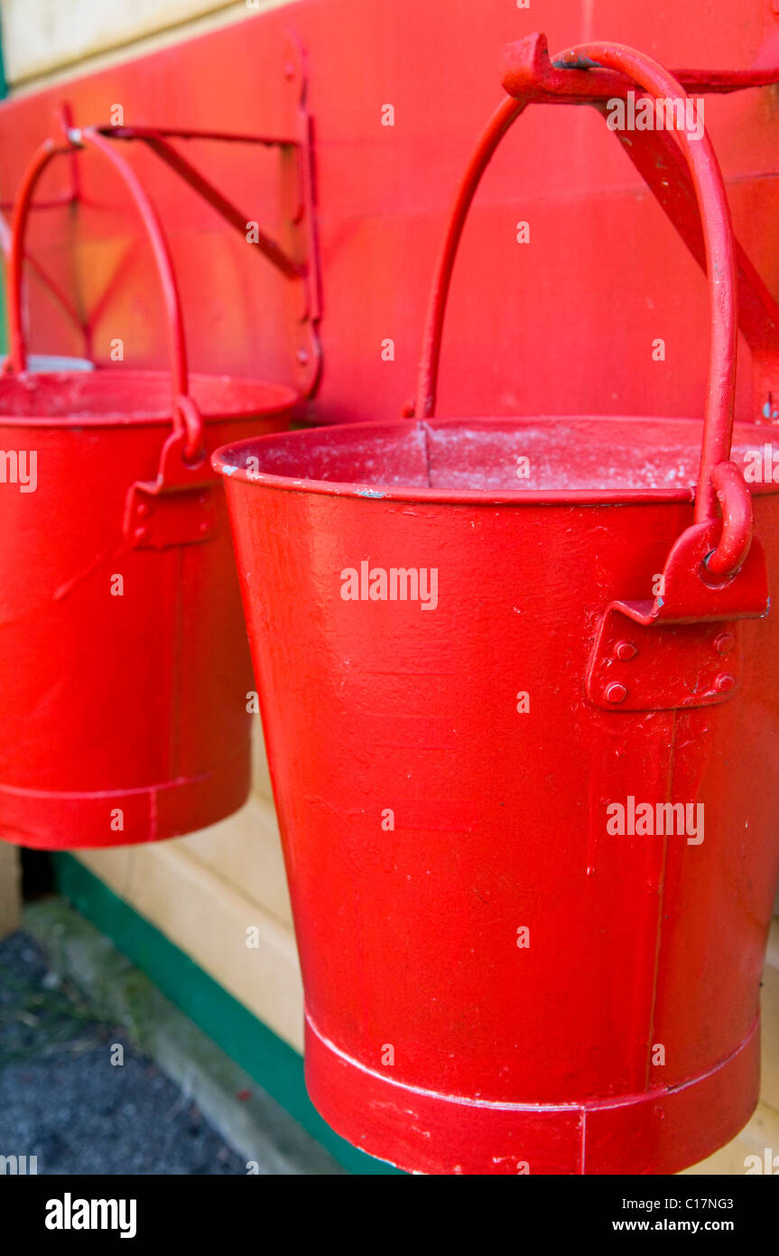 Two Red Painted Water Buckets Hanging Up Stock Photo