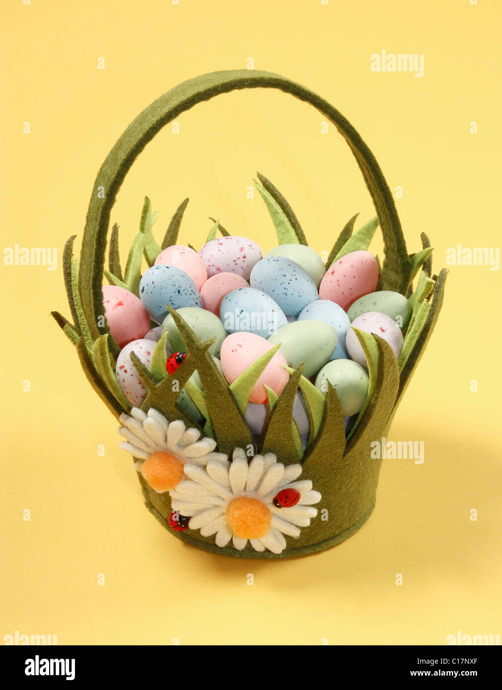 Green Easter Basket with Eggs on Yellow Background. Stock Photo