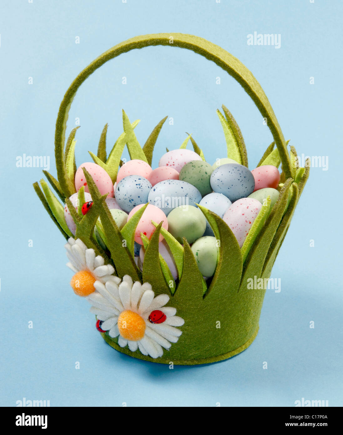 Green Easter Basket with Eggs on Blue Background. Stock Photo