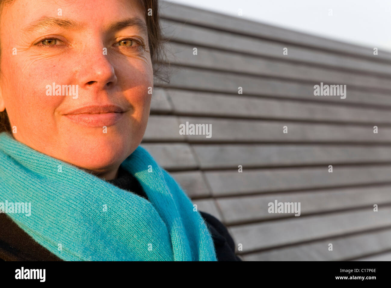 Woman, 40 years old sitting on a bench enjoying in the evening sun, St ...