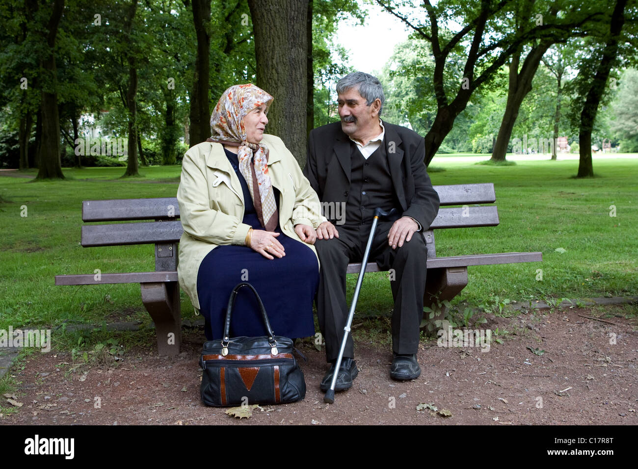 An elderly Turkish couple sitting on a bench in a park, Herne, Germany Stock Photo