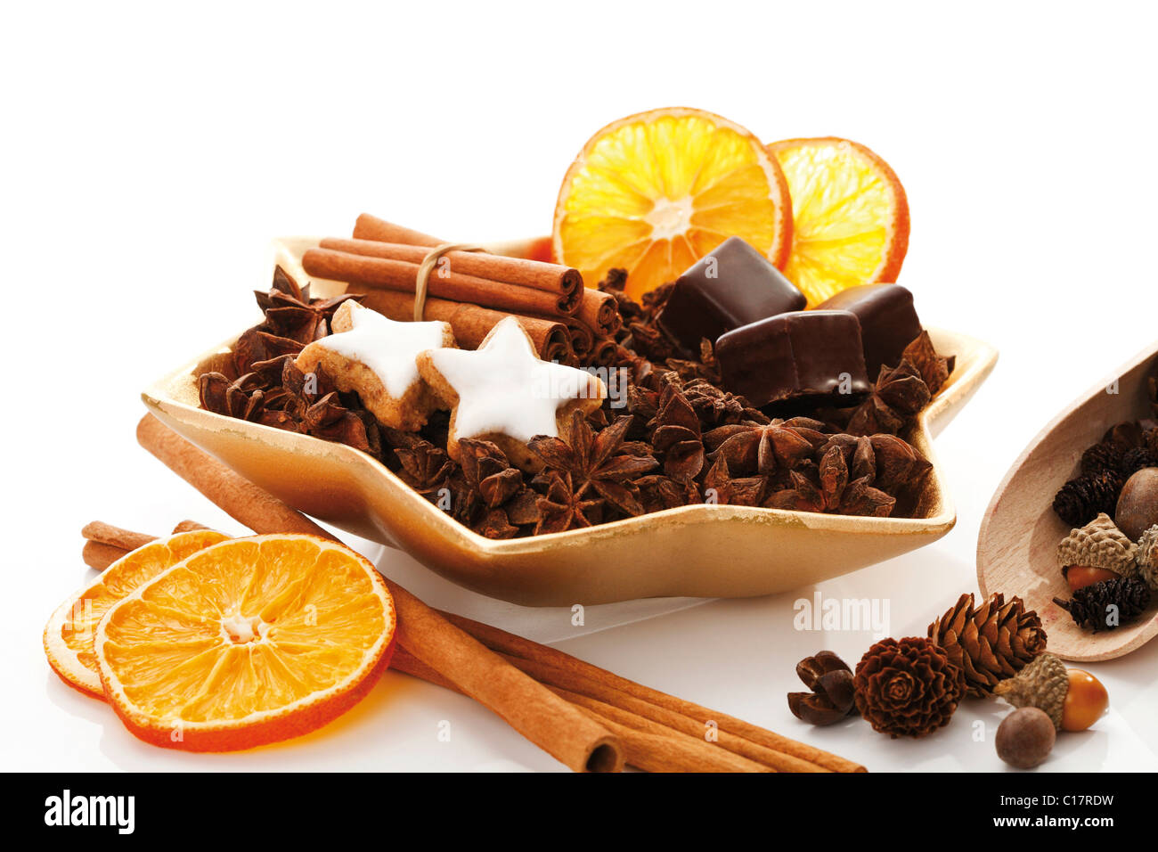 Star-shaped platter with star anise, cinnammon sticks, dried organge slices, cinnammon star-shaped biscuits and dominos Stock Photo