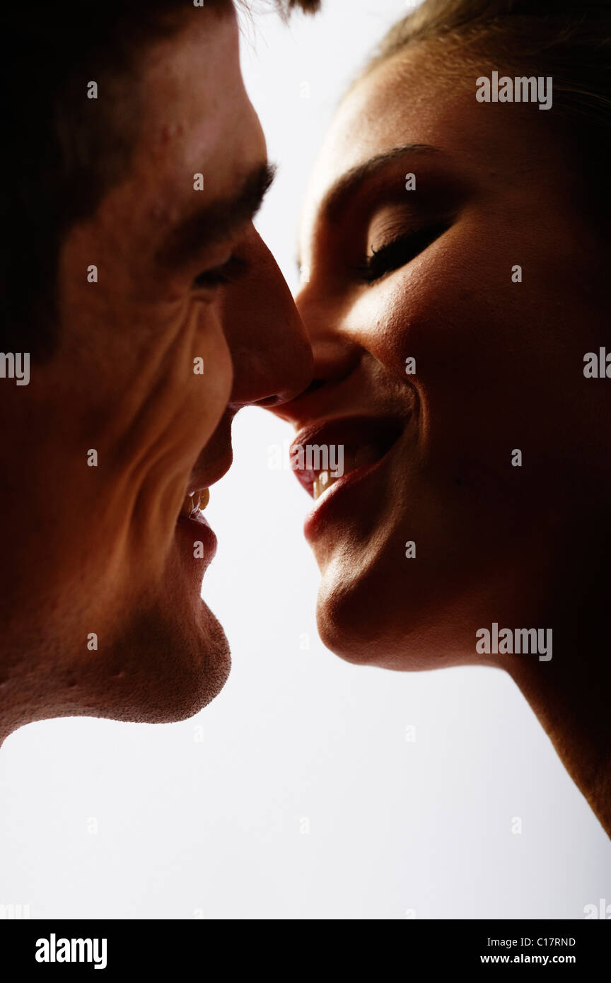 Lovers laughing and kissing, backlight Stock Photo