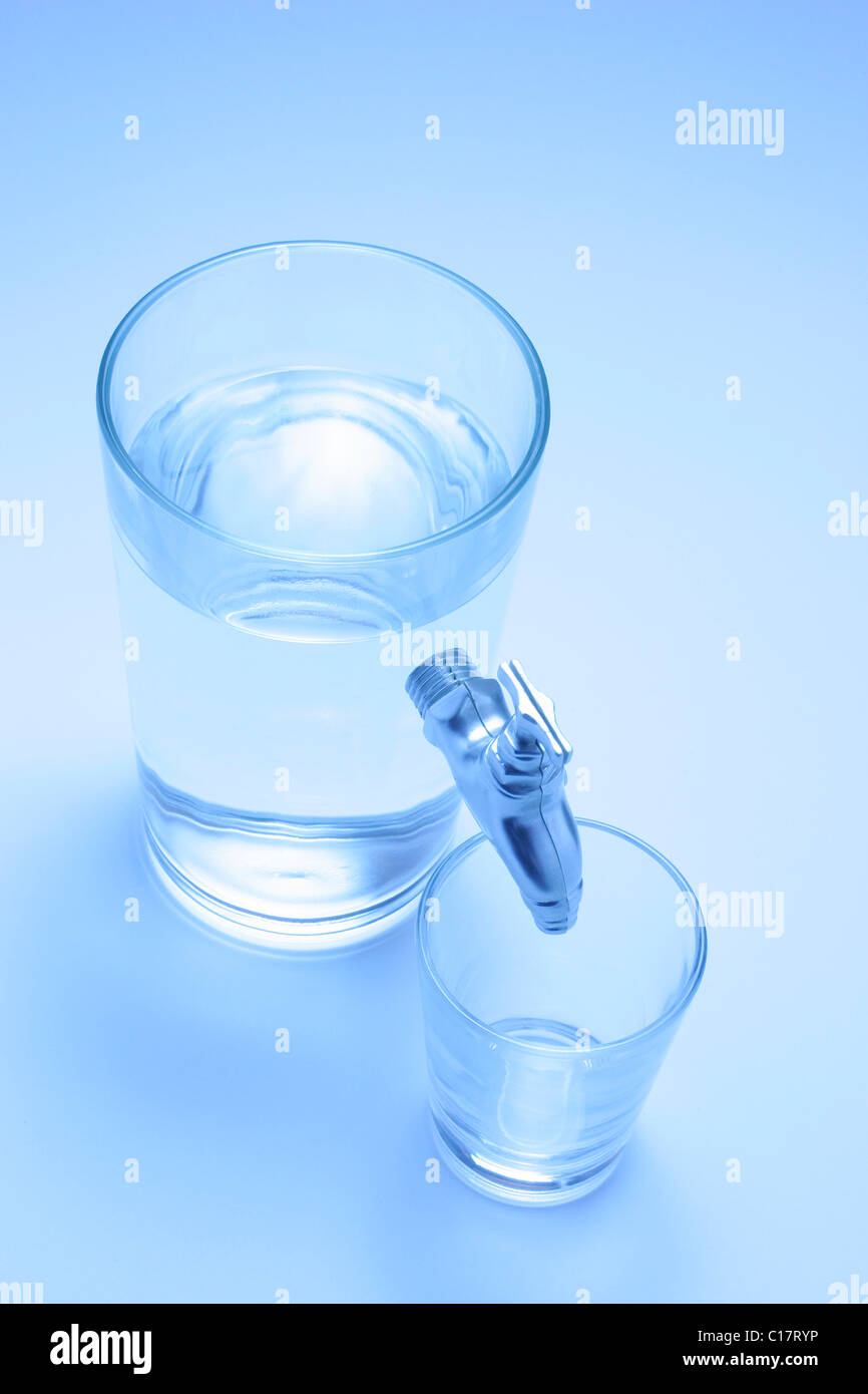 Water tap extending from a glass Stock Photo